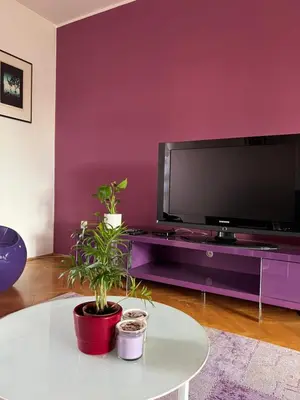 a living room with a purple wall and a tv at Apartment Ljubljana - Free parking in Ljubljana