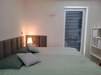 a bedroom with a large bed and a window at Downtown Delight in Ljubljana
