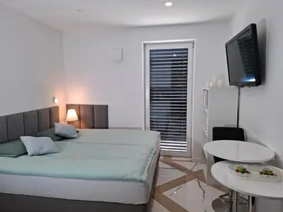 a bedroom with a bed and a table and a tv at Downtown Delight in Ljubljana