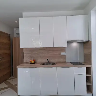 a kitchen with white cabinets and a sink at Downtown Delight in Ljubljana