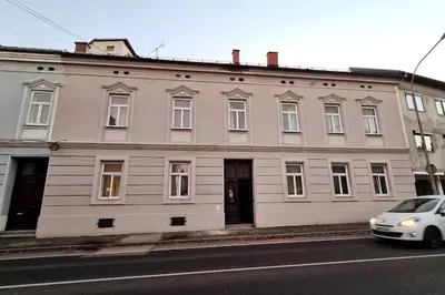 a white car parked in front of a large building at Oldie goldie in Maribor