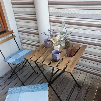 a small table with flowers and a glass bottle on it at River House Radolca in Radovljica
