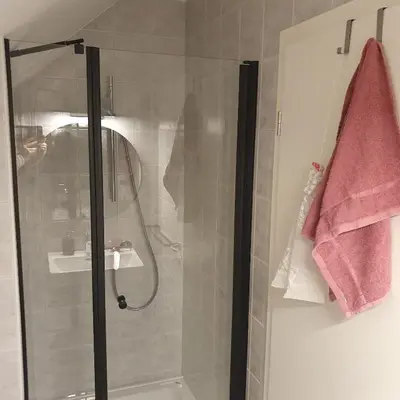 a bathroom with a shower with a glass door at River House Radolca in Radovljica
