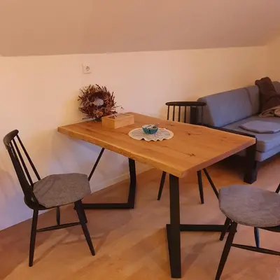 a living room with a wooden table and chairs at River House Radolca in Radovljica