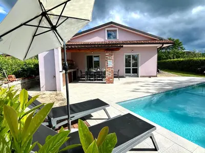 a house with an umbrella and a swimming pool at Resort Franko Spacious house with a pool in Obrov
