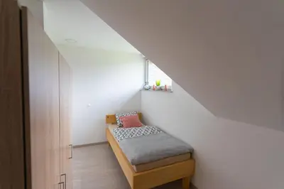 a small room with a bed in a stair case at Apartma Fantazija in Ribnica