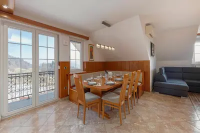 a dining room with a table and chairs and a couch at Apartments Way to Heaven in Dol pri Ljubljani