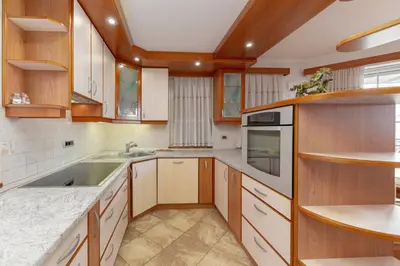 a kitchen with wooden cabinets and a sink at Apartments Way to Heaven in Dol pri Ljubljani