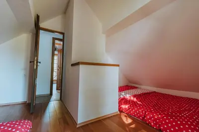 a room with a red bed in the corner at Brunarica Dežno in Makole