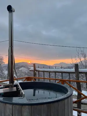a hot tub with the sunset in the background at Brunarica Dežno in Makole