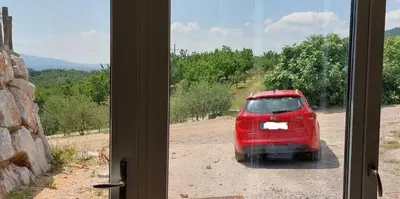 a view of a red car parked outside a window at Apartment with a view in Dobravlje