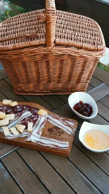 a table with a picnic basket and a tray of cheese at Apartment with a view in Dobravlje
