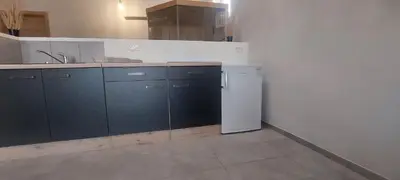 a kitchen with blue cabinets and a white refrigerator at Apartment with a view in Dobravlje