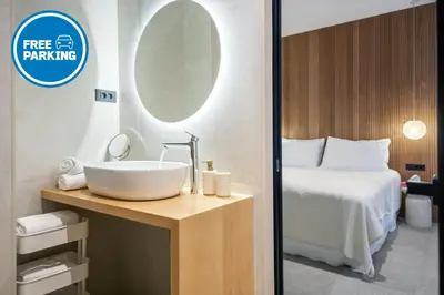 a bathroom with a sink and a bed with a mirror at Bugabu Ljubljana in Ljubljana
