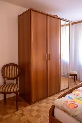 a bedroom with a wooden cabinet and a chair at Premium house Anika in Rogaška Slatina
