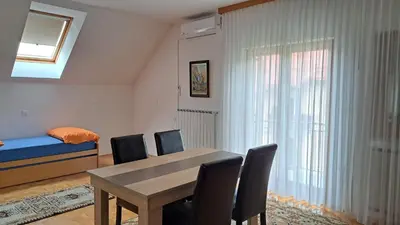 a dining room with a table and chairs and a bed at Premium house Anika in Rogaška Slatina