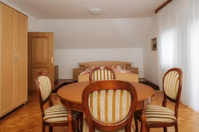 a dining room with a table and chairs and a bed at Premium house Anika in Rogaška Slatina