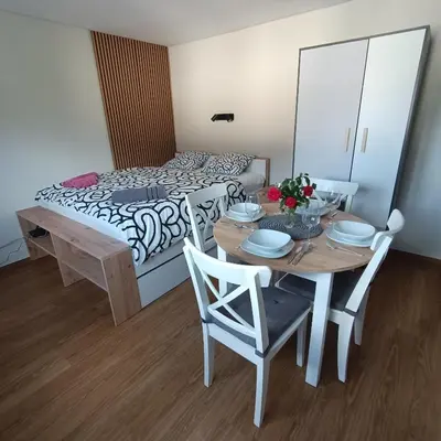 a dining room with a table and a bed at Apartma z lepo teraso za 3+1 osebe in Bled