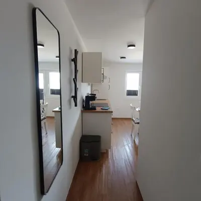 a room with a mirror and a kitchen with a counter at Apartma z lepo teraso za 3+1 osebe in Bled