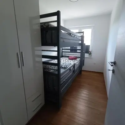 a bunk bed in a room with a closet at Apartma z lepo teraso za 3+1 osebe in Bled