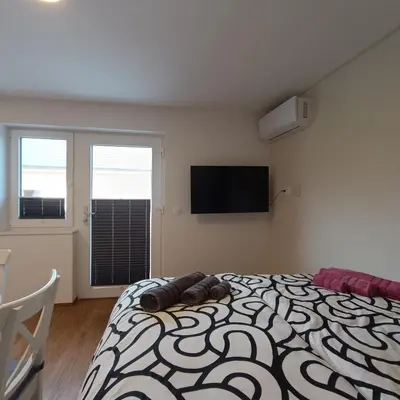 a bedroom with a bed and a flat screen tv at Apartma z lepo teraso za 3+1 osebe in Bled