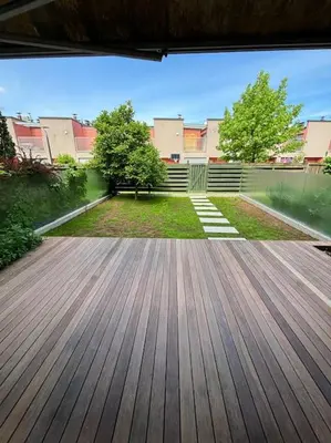 a large wooden deck in a yard with buildings at Dreamy nature apartment near city-family friendly, FREE parking in Ljubljana