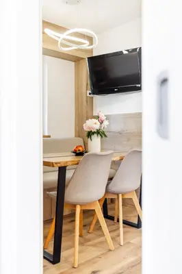 a dining room table with two chairs and a tv at Apartment Tina - Lipa 33 in Podčetrtek