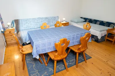 a room with a table and chairs and a bed at Apartments Dominika Štros in Bohinj