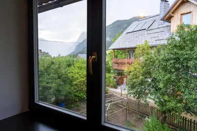 a window with a view of a house at Apartments Dominika Štros in Bohinj