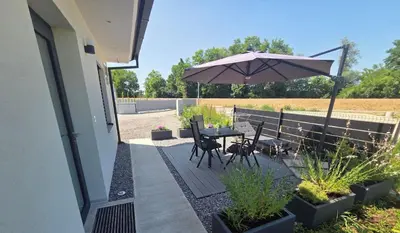 a patio with a table and chairs and an umbrella at Apartma Lajf in Brežice