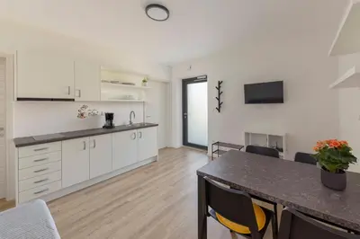 a kitchen and dining room with white cabinets and a table at Apartma Lajf in Brežice