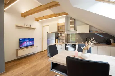 a kitchen and dining room with a table and chairs at Forest Breeze Apartments in Blejska Dobrava