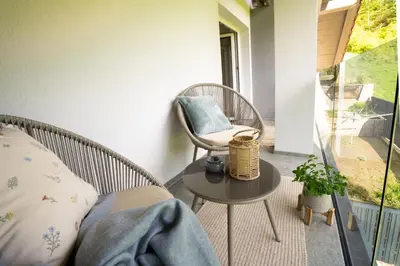 a room with a chair and a table on a porch at Forest Breeze Apartments in Blejska Dobrava