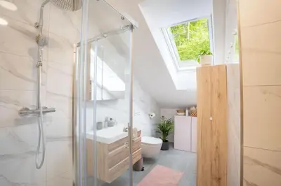 a bathroom with a glass shower and a toilet at Forest Breeze Apartments in Blejska Dobrava
