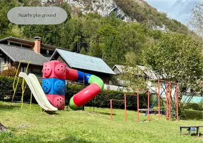 a playground with a slide in a park at Forest Breeze Apartments in Blejska Dobrava