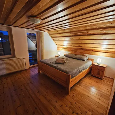 a bedroom with a bed with a wooden ceiling at TRUTH WINES HOUSE in Veliki Vrh
