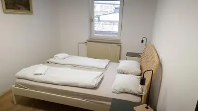 a bedroom with two beds with white sheets and a window at Ljubljana rest nest in Ljubljana