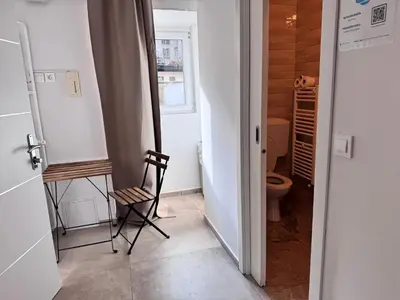 a bathroom with a toilet and a chair in it at Ljubljana rest nest in Ljubljana