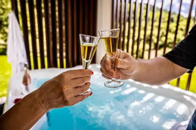 two people holding champagne glasses at a table at Brkinka Apartments in Vremski Britof