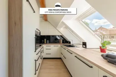 a kitchen with white cabinets and a large window at Apartma pri Jakobu in Postojna