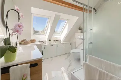 a white bathroom with a toilet and a sink at Apartma pri Jakobu in Postojna