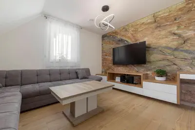 a living room with a couch and a flat screen tv at Apartma pri Jakobu in Postojna
