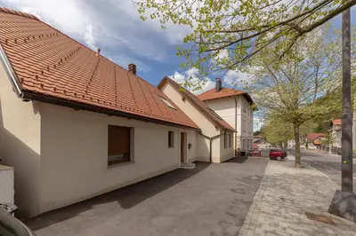 a building with a red roof on a street at Apartma pri Jakobu in Postojna