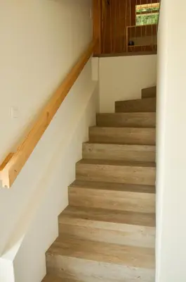 a staircase with wood flooring in a house at Hiška ob gozdu Lukez plac in Ljubno