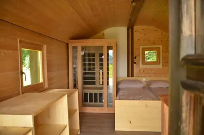 a room with a bed in a wooden cabin at Hiška ob gozdu Lukez plac in Ljubno