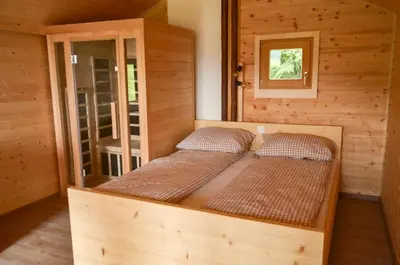 a bedroom with two beds in a wooden cabin at Hiška ob gozdu Lukez plac in Ljubno
