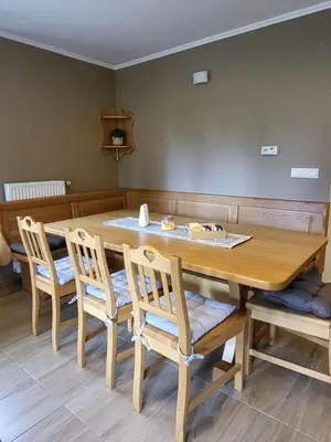 a dining room table with four chairs around it at Rogla apartma Rdeča kapica in Vitanje
