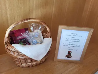 a basket with a card next to a picture at Rogla apartma Rdeča kapica in Vitanje