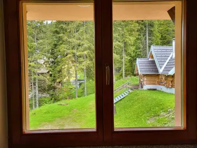 a window with a view of a house at Rogla apartma Rdeča kapica in Vitanje