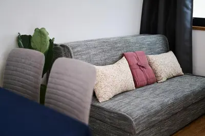 a gray couch with pillows on it in a living room at Mozirje Comfort Apartments in Mozirje